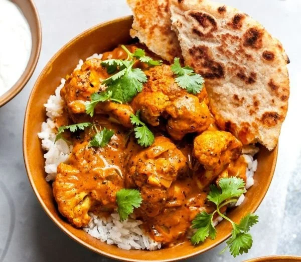 Creamy butter cauliflower dish garnished with herbs