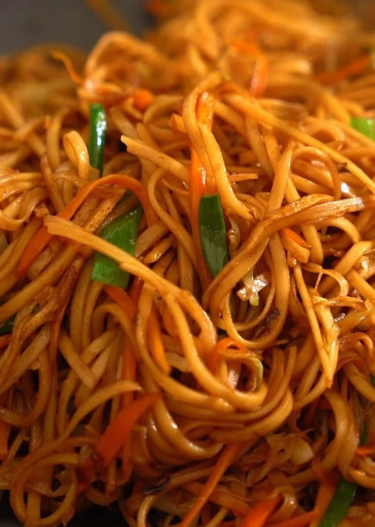 A plate of Chow Mein with colorful vegetables and noodles