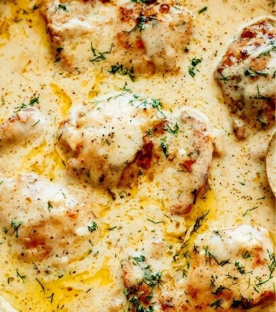 Creamy oven baked chicken thighs plated with herbs and spices