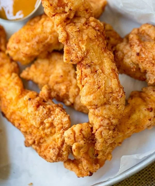 Crispy chicken tenders served with dipping sauce