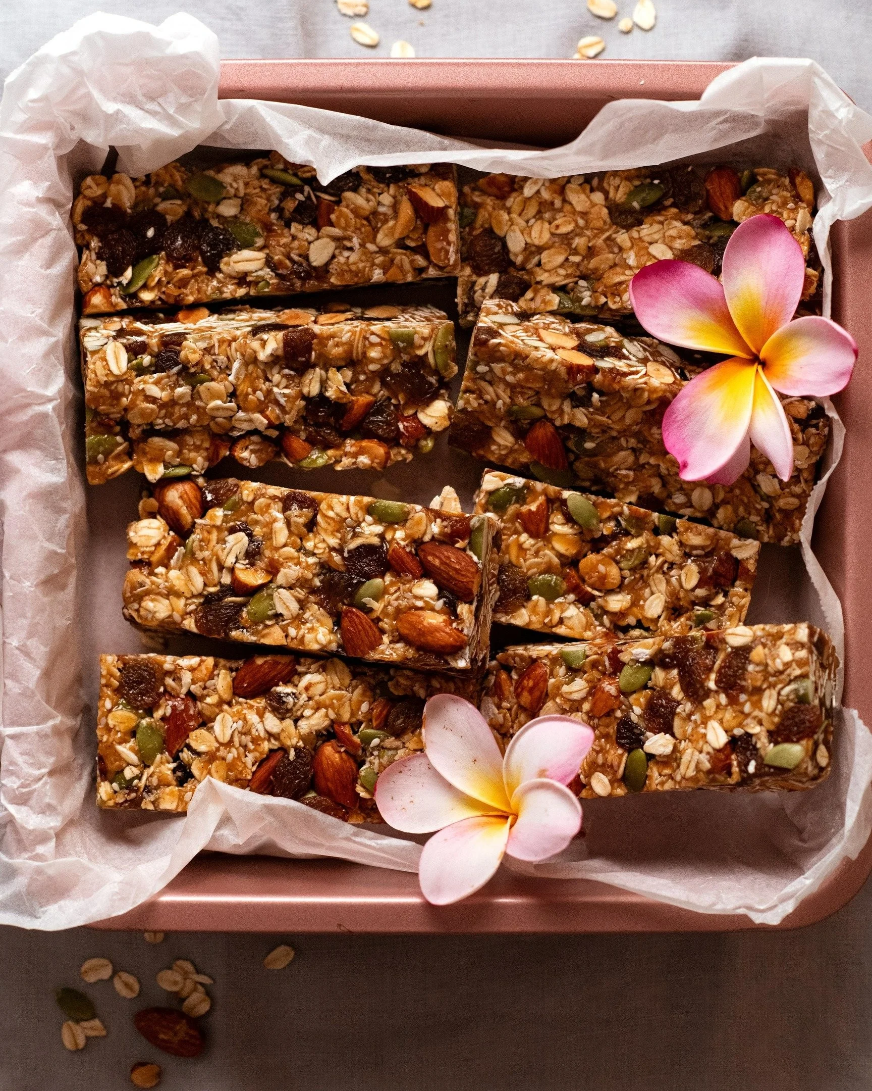 A plate of homemade muesli bars made with oats, nuts, and dried fruits.