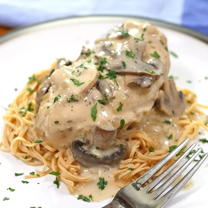 Delicious slow cooker chicken and mushrooms dish garnished with herbs.