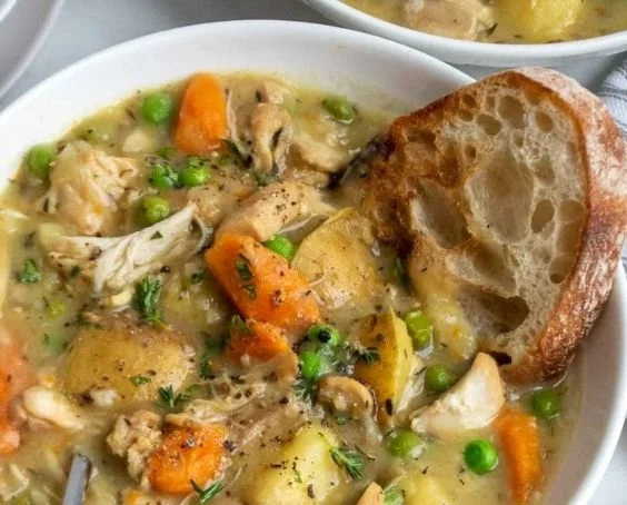 Delicious slow cooker chicken stew in a bowl topped with fresh herbs.