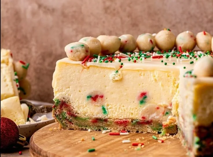 Delicious sugar cookie cheesecake topped with whipped cream and sprinkles