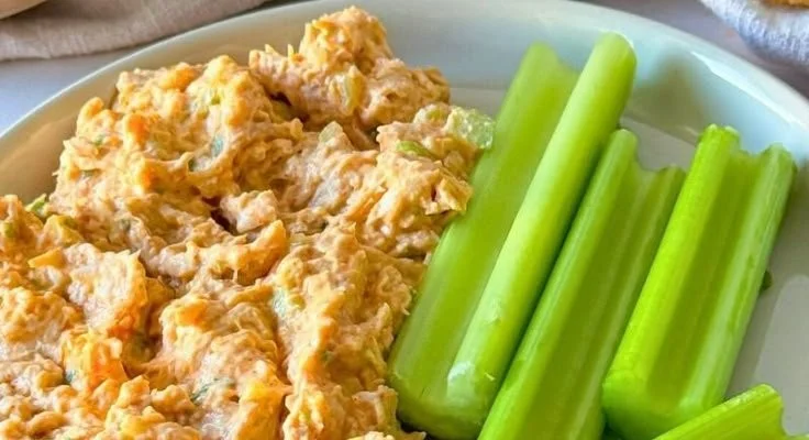 A vibrant Buffalo Chicken Salad topped with spicy chicken, celery, and ranch dressing.