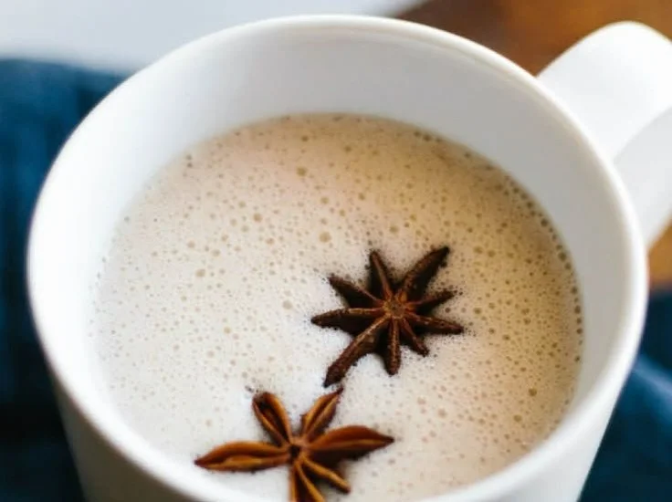 A cup of chai spiced coconut milk topped with spices, showcasing a warm beverage.