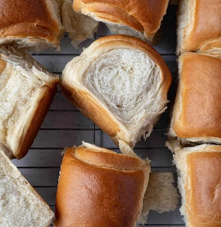 Freshly baked vegan dinner rolls on a wooden table