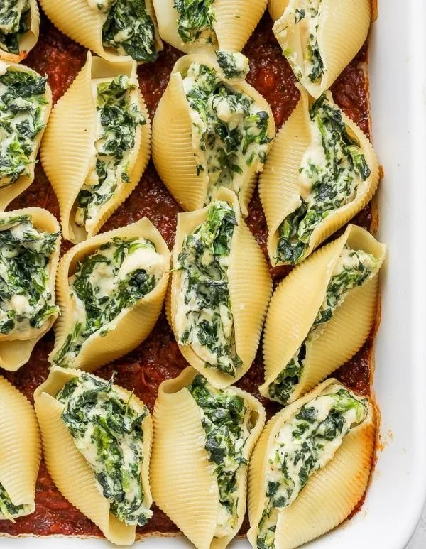 Vegan stuffed shells filled with plant-based ingredients and topped with sauce