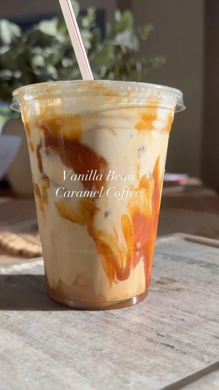 A refreshing glass of caramel vanilla iced coffee topped with whipped cream.