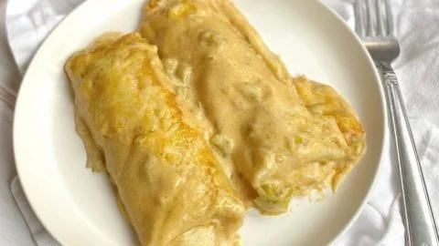 Delicious easy creamy white chicken enchiladas ready to serve.