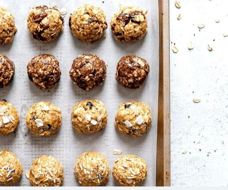 A variety of homemade energy balls made with nuts, seeds, and dried fruits.