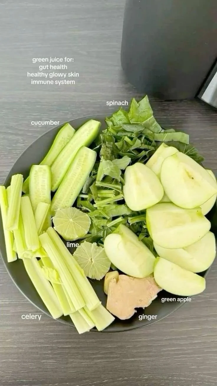 Fresh green juice ingredients including spinach, kale, and cucumber.