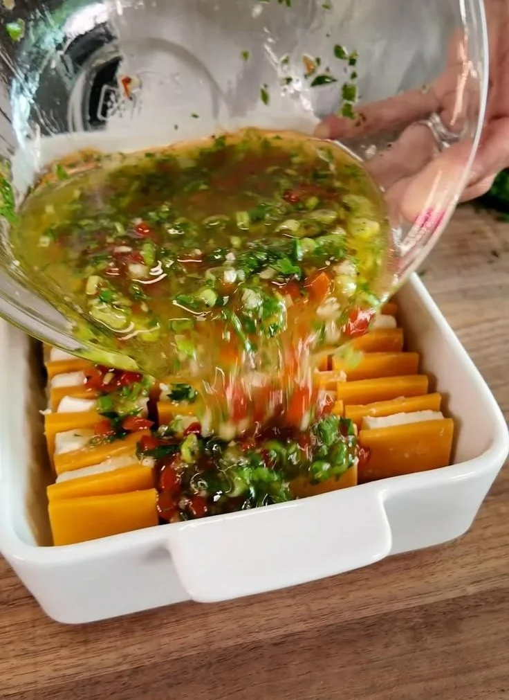 A plate of marinated cheese with herbs and spices for a delectable appetizer.