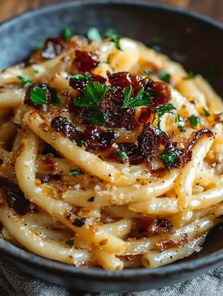 Delicious plate of pasta with caramelized onions garnished with herbs