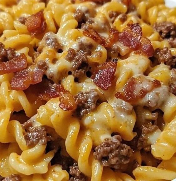 Plate of loaded bacon cheeseburger pasta topped with cheese and crispy bacon