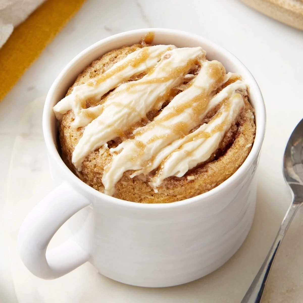 Delicious protein-packed Zimtschnecken-Tassenkuchen in a cozy mug.