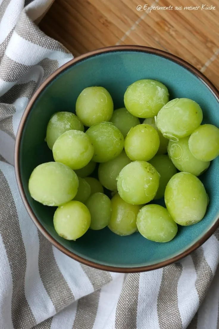 A bowl of frozen grapes, a perfect healthy snack for movie nights.