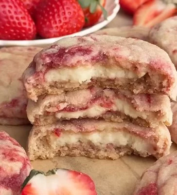 Delicious strawberry cheesecake cookies on a plate decorated with fresh strawberries