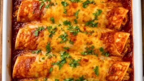 Bobby Flay chicken enchiladas served on a plate with toppings.