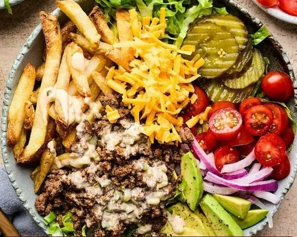 Delicious cheeseburger bowls loaded with toppings like lettuce, cheese and pickles.