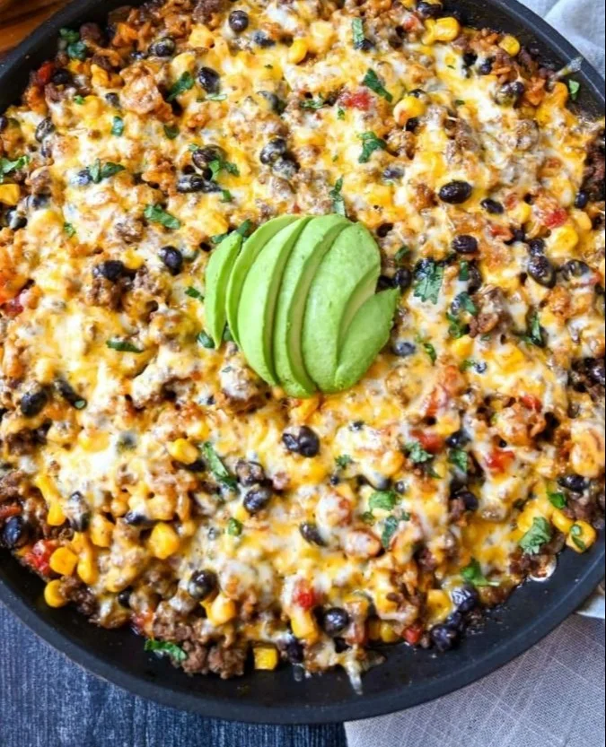 Cheesy Taco Rice Skillet topped with cheese and garnished, delicious and easy recipe