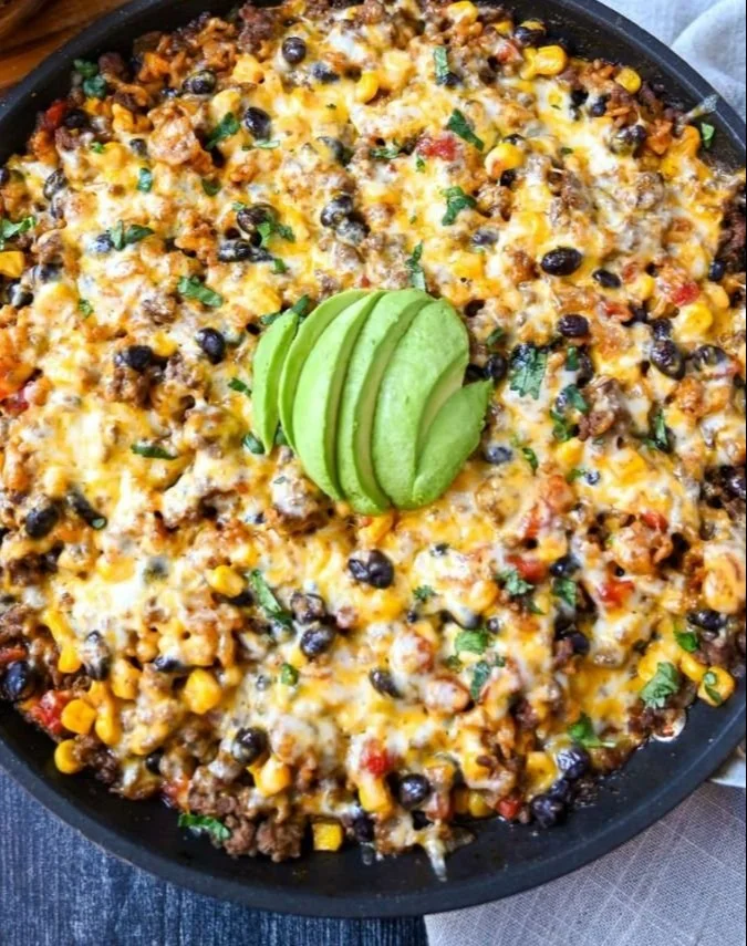Cheesy Taco Rice Skillet garnished with cilantro and served in a skillet.