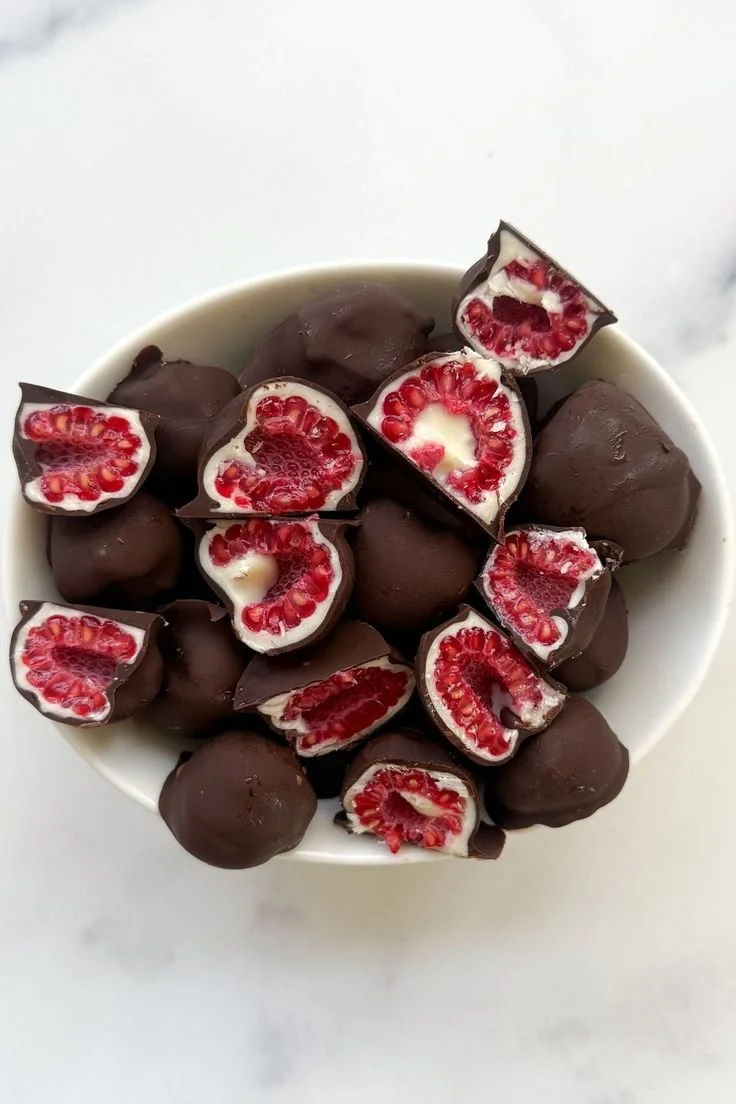 Delicious chocolate covered raspberries on a white plate