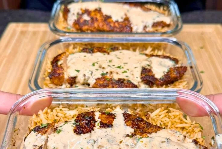 Creamy Cajun Chicken and Rice Bowls served in a white bowl with herbs on top