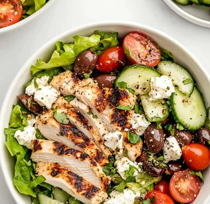 Fresh Greek salad with chicken, olives, tomatoes, cucumbers, and feta cheese.
