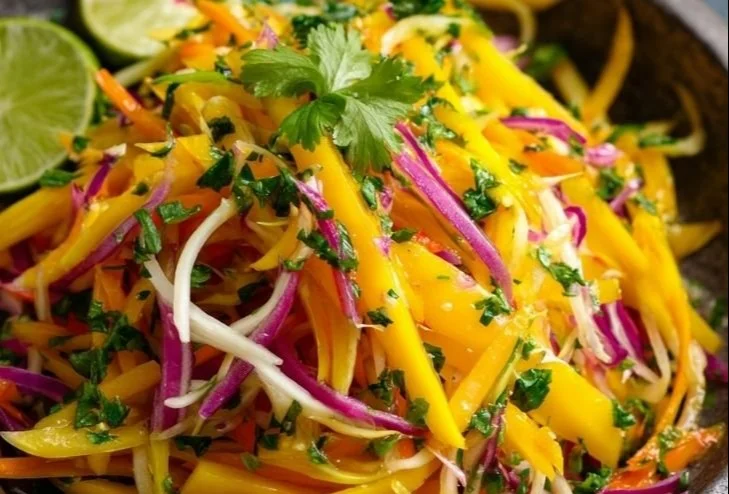 Colorful mango slaw with fresh vegetables served in a bowl