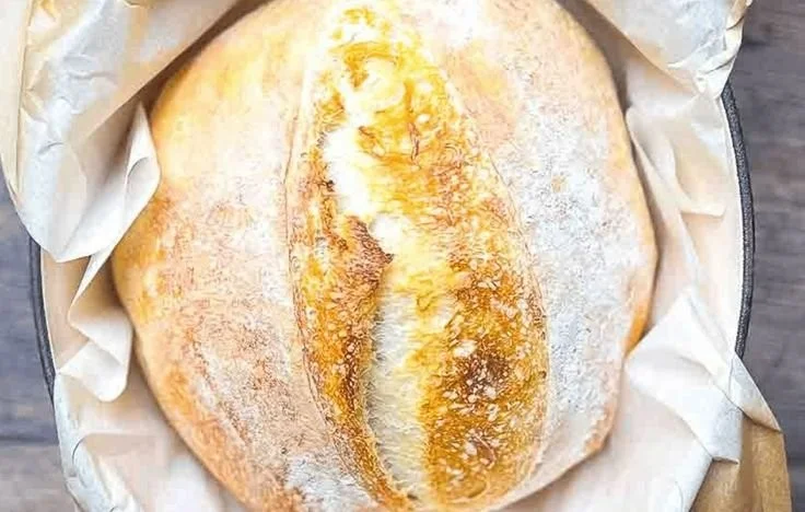 Slice of no-fail sourdough bread on a wooden cutting board