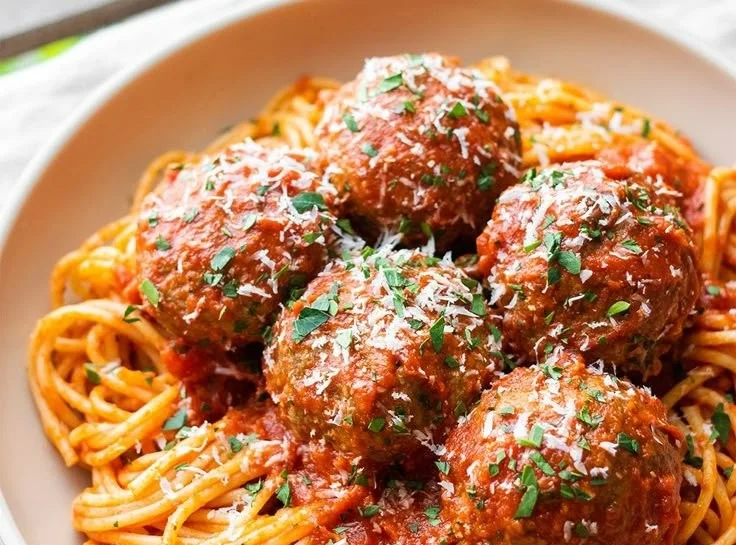 Delicious oven-baked Italian meatballs served with marinara sauce and herbs