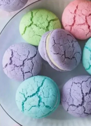 Colorful pastel sugar cookie sandwiches filled with creamy frosting.