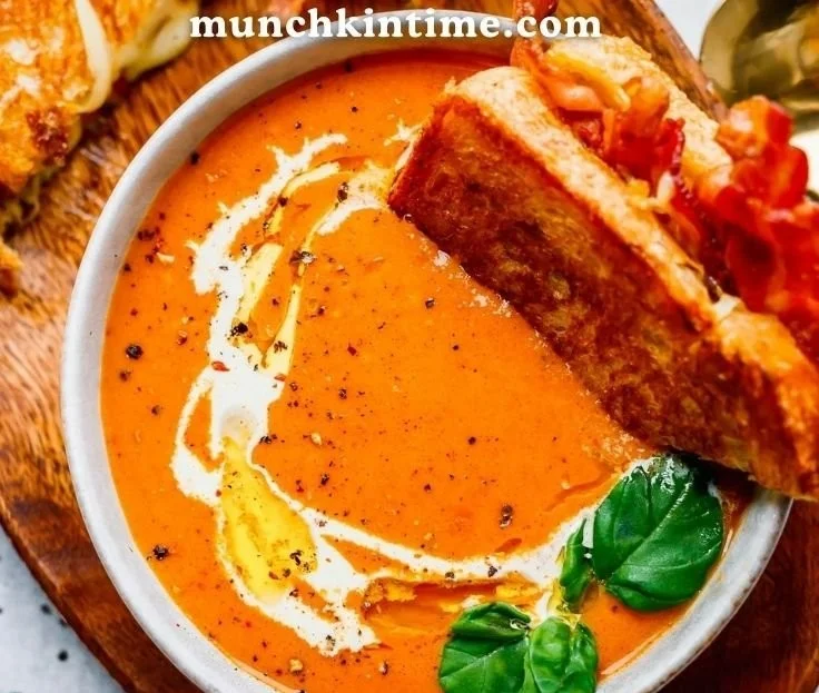 Bowl of creamy Tomato Bisque soup garnished with fresh herbs.