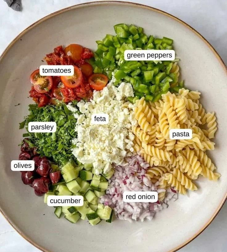 Bowl of colorful Vegan Greek Pasta Salad with fresh vegetables and olives