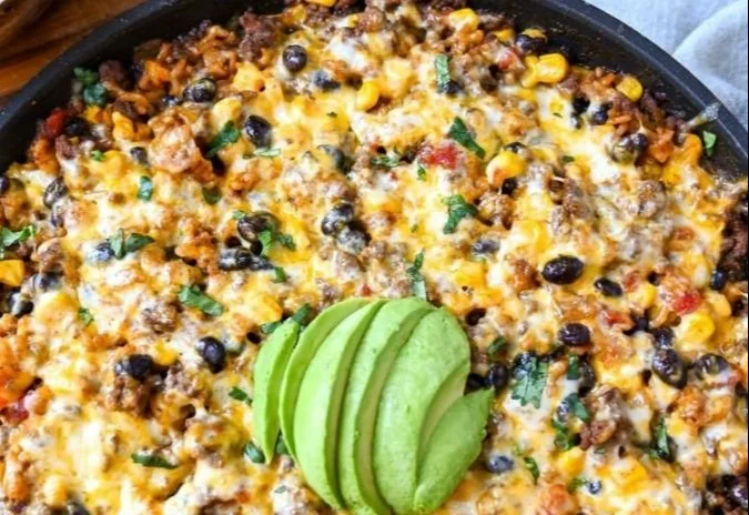 Cheesy taco rice skillet with ground beef, cheese, and colorful veggies