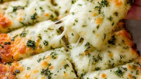 Cheesy zucchini breadsticks served on a platter with marinara sauce