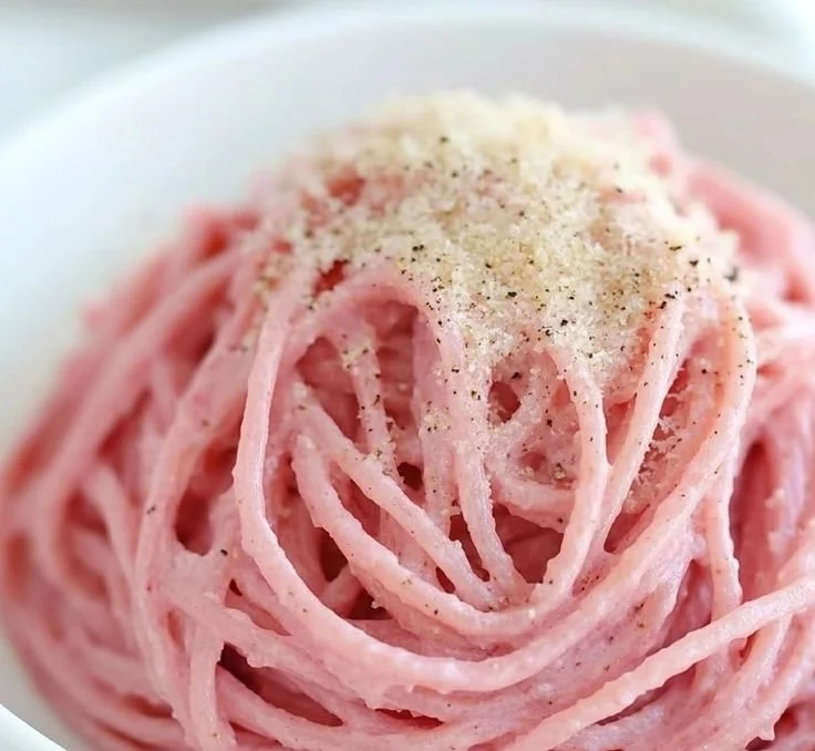 Bowl of creamy vegan pink pasta topped with fresh basil
