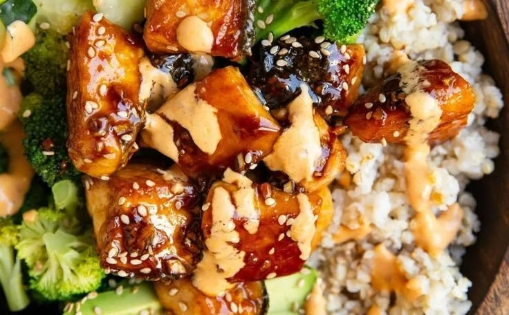 Crispy Bang Bang Salmon bites served in a colorful bowl with fresh vegetables.