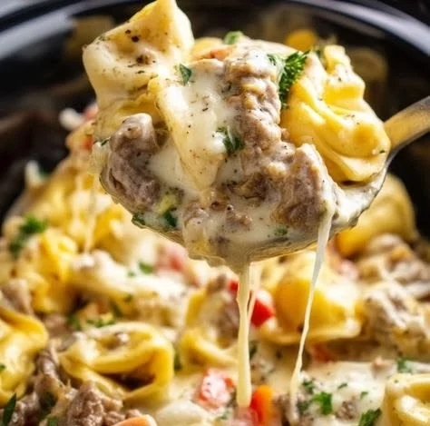 Delicious bowl of Crock Pot Cheesesteak Tortellini topped with herbs.