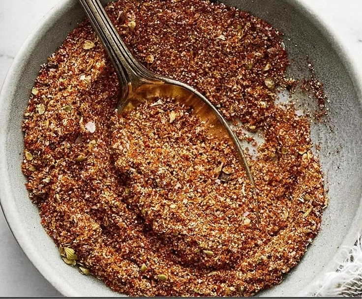 Bowl of homemade fajita seasoning with spices for cooking.