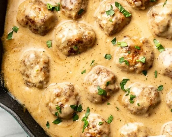 Plate of homemade IKEA meatballs served with lingonberry sauce and potatoes