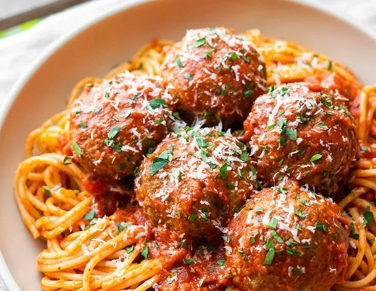 Oven-baked Italian meatballs on a plate with tomato sauce