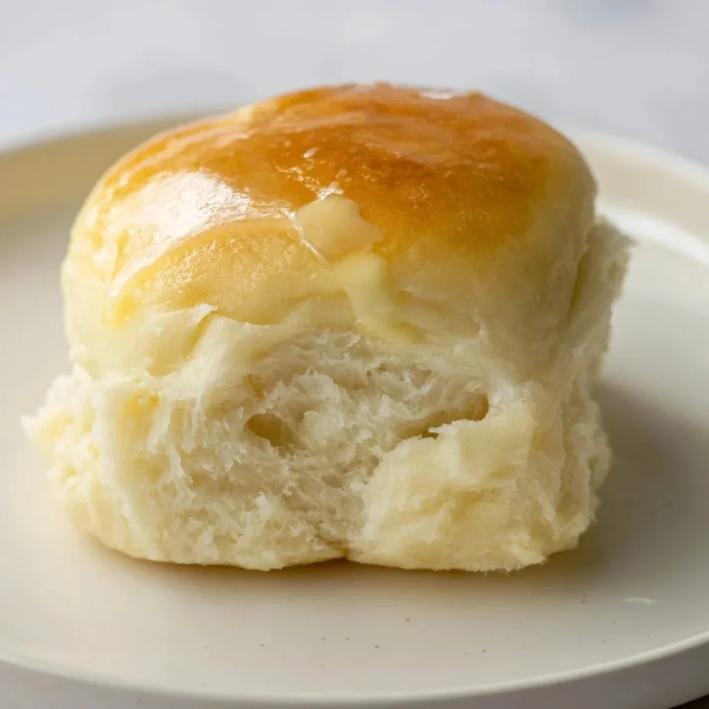 Freshly baked soft quick-rise dinner rolls on a wooden table