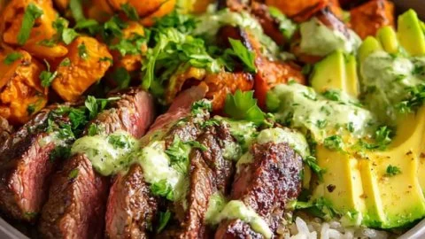 Steak and sweet potato bowls topped with avocado-cilantro drizzle.