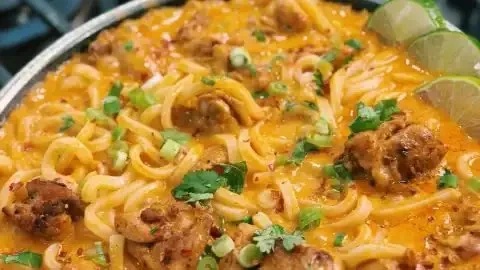 Thai-inspired coconut red curry chicken udon dish with vibrant colors and textures.