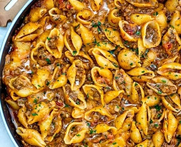 Creamy beef and shells dish served in a bowl, garnished with parsley.