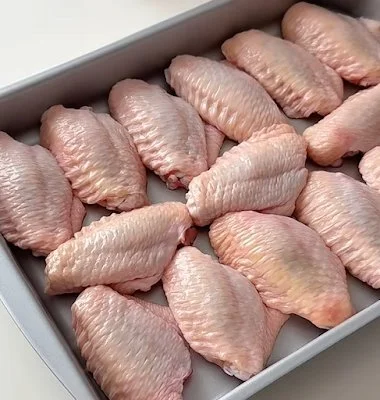 Plate of crispy fried chicken wings garnished with herbs and spices